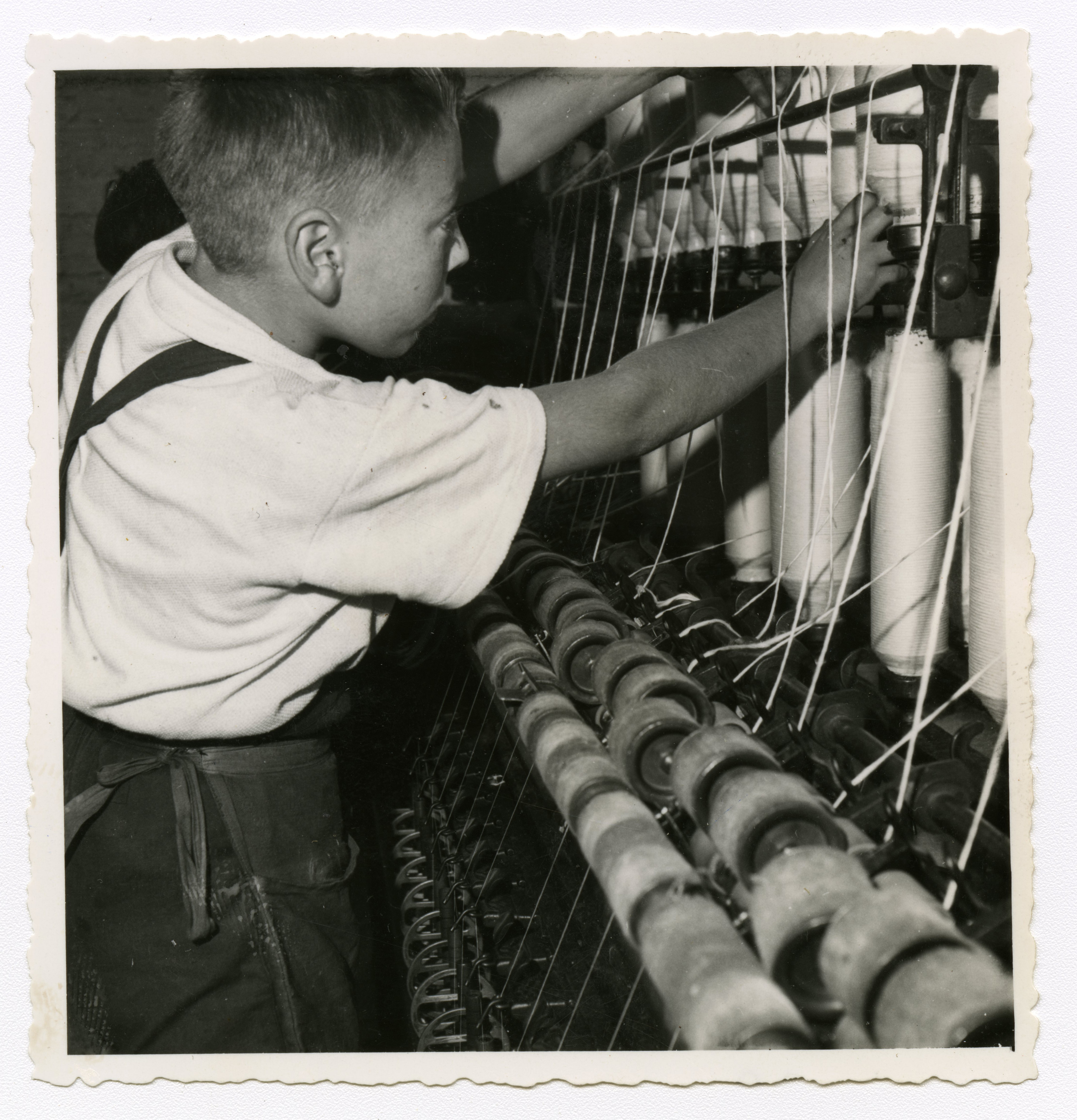 Jeune ouvrier travaillant sur un métier à tisser : tirage photographique, Lille (Nord), vers 1955.