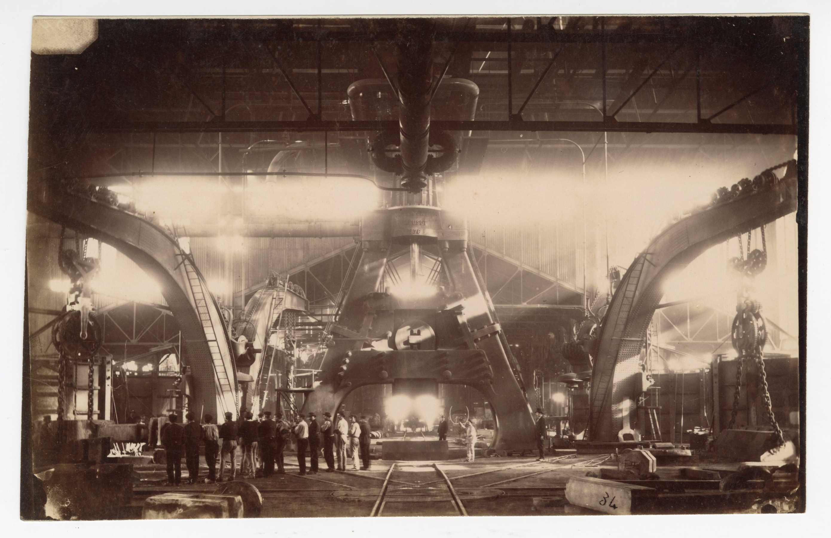 Travailleurs regroupés devant le marteau-pilon des aciéries Schneider : tirage photographique, Le Creusot (Saône-et-Loire), sans date.