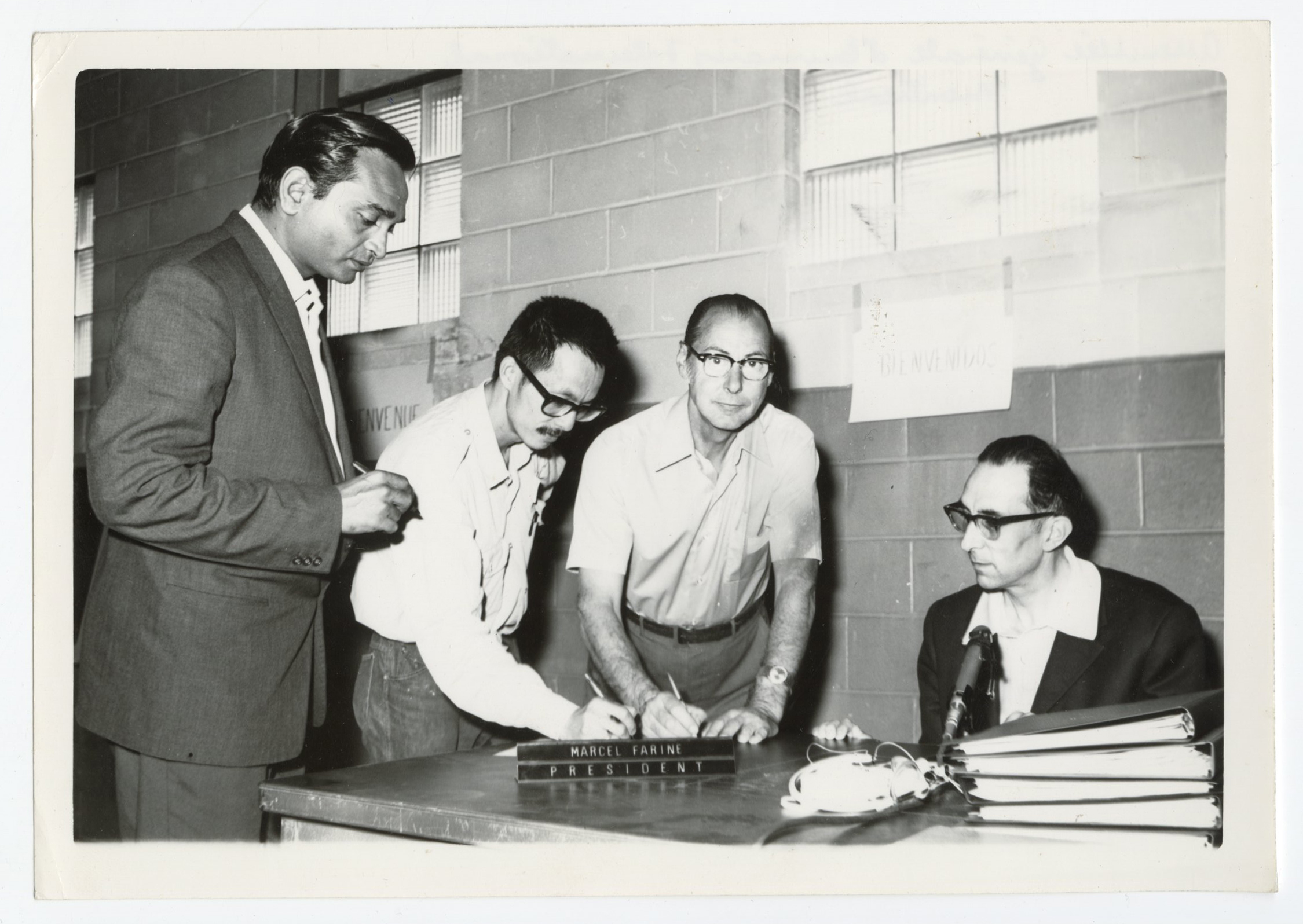 Photographie montrant des membres de Emmaüs international signant les statuts de l'association lors de la deuxième assemblée mondiale (1971).