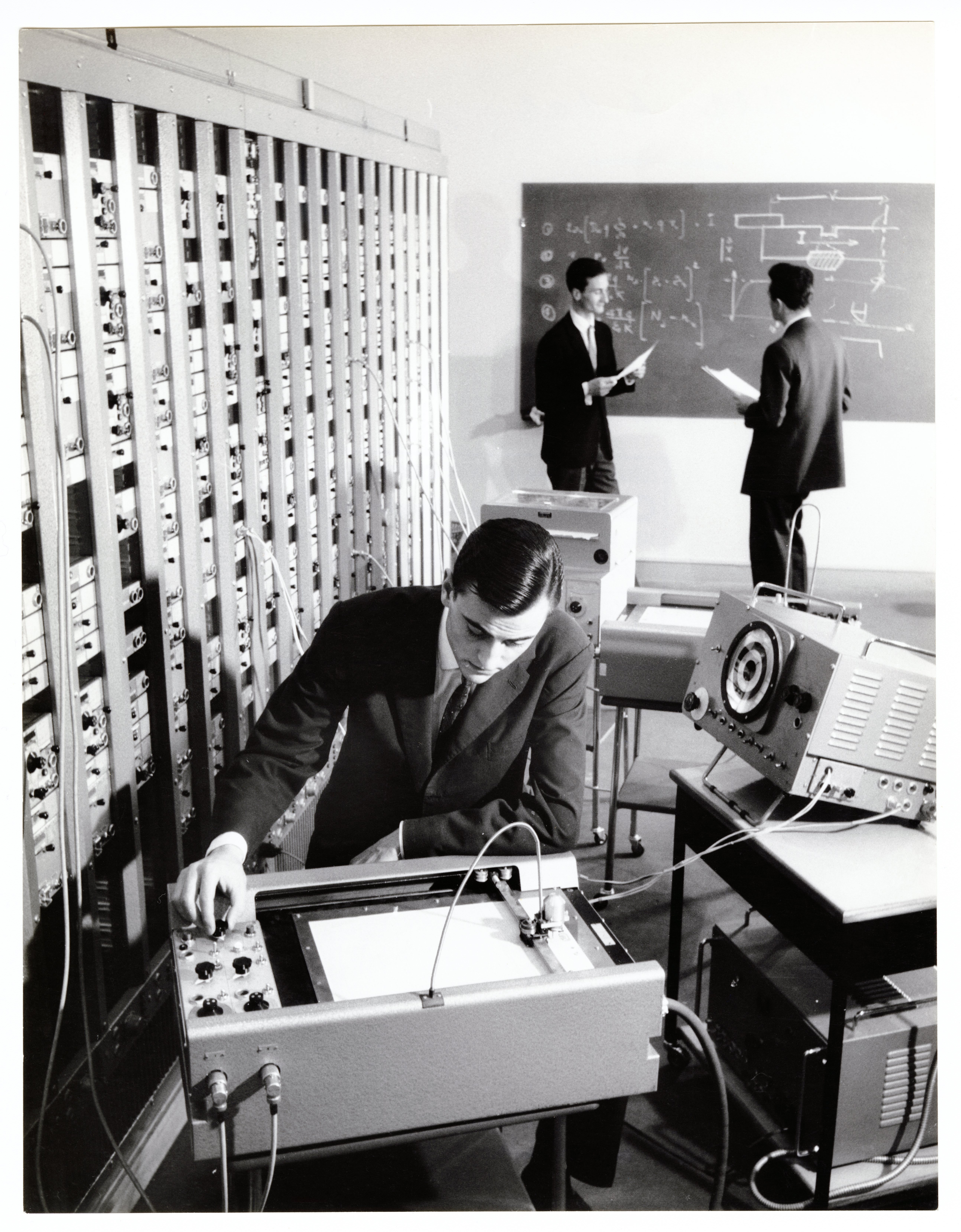 Ingénieur et physiciens participant au « Plan calcul » (plan gouvernemental destiné à rattraper le retard français en matière de nouvelles technologies) : tirage photographique, lieu inconnu, années 1960.