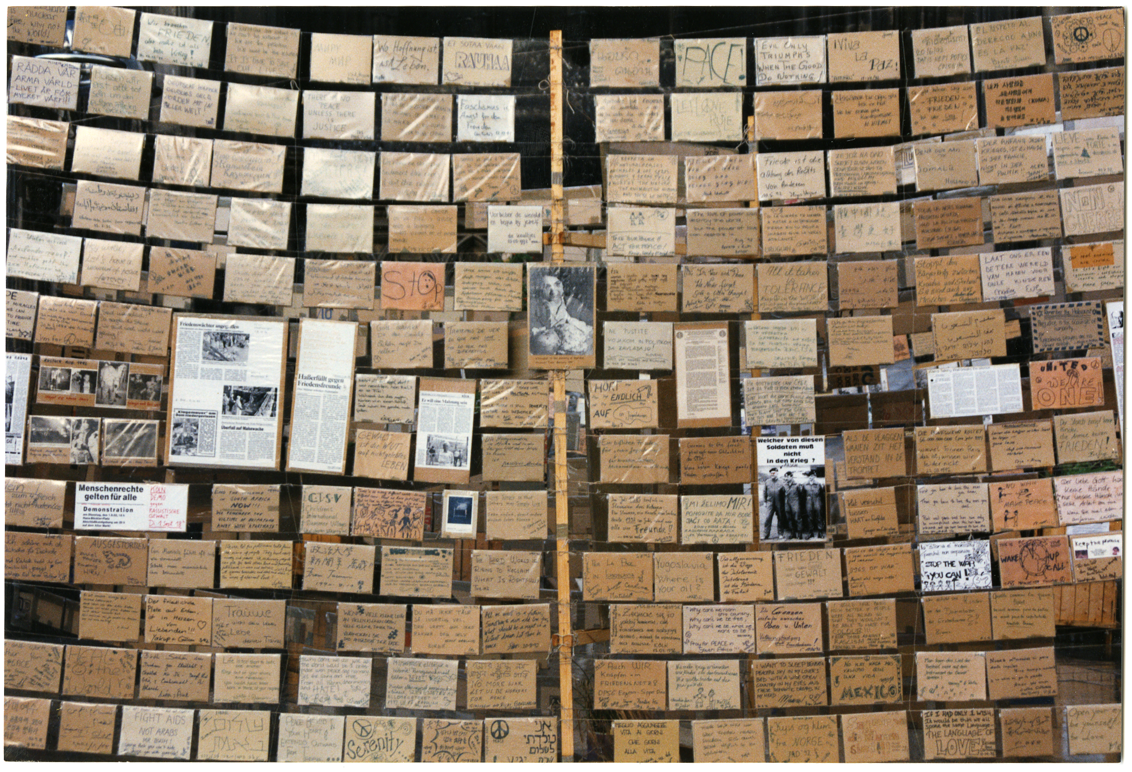 Photographie des messages laissés par les membres d'Emmaüs International sur le parvis de la cathédrale de Cologne, 1992.
