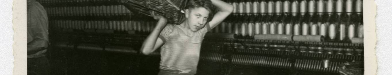 Un jeune apprenti circule dans une filature, années 1950. ANMT 1989 9 484, Le Blan (filature)