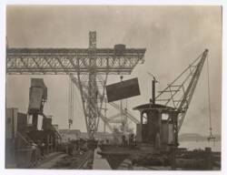 Photographie d'ouvriers indochinois et contremaîtres sur le chantier de construction d'un quai sur la rive droite de la rivière de Saigon, 1907-1910 : bétonnières et emploi du gravillon.