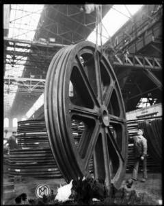 Photo de l'usine Baume et Marpent, roue industrielle de plein pied avec un homme sur le côté.