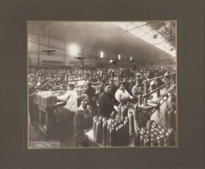 Ouvrières fabriquant des obus pour la société L’Éclairage électrique, photographie extraite de l’album Usine de Suresnes. Fabrication des obus explosifs de 75 mm et des gaines relais, 1914-1916  ANMT PI 41 1, Pièces isolées iconographiques