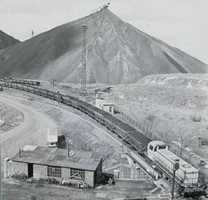 Vue aérienne du terril n°19 de Lens (Pas-de-Calais) avec un train transportant de la houille en premier plan, 1965.