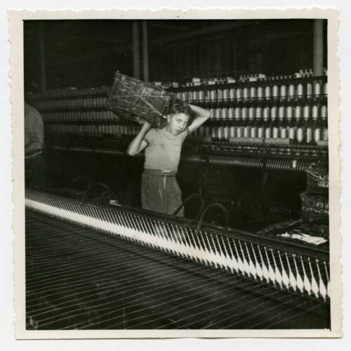 Un jeune apprenti circule dans une filature, années 1950. ANMT 1989 9 484, Le Blan (filature)