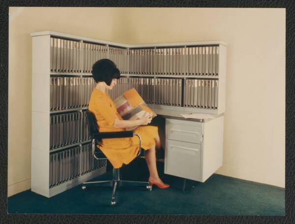 Une femme pose devant un meuble à classeurs, s.d. ANMT 2002 6 22, Ronéo (fabricant de duplicateurs, de matériels et mobilier bureau).
