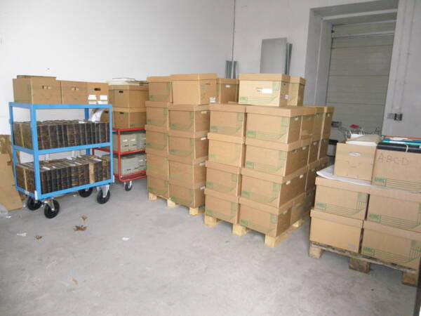 Boîtes d'archives empilées sur chariots et palettes
