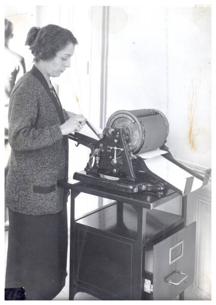Une femme utilise un "Ronéocopier" (machine servant à copier le courrier) : photographie, s.d. ANMT 2002 6 22, Ronéo (fabricant de duplicateurs, de matériels et mobilier bureau).